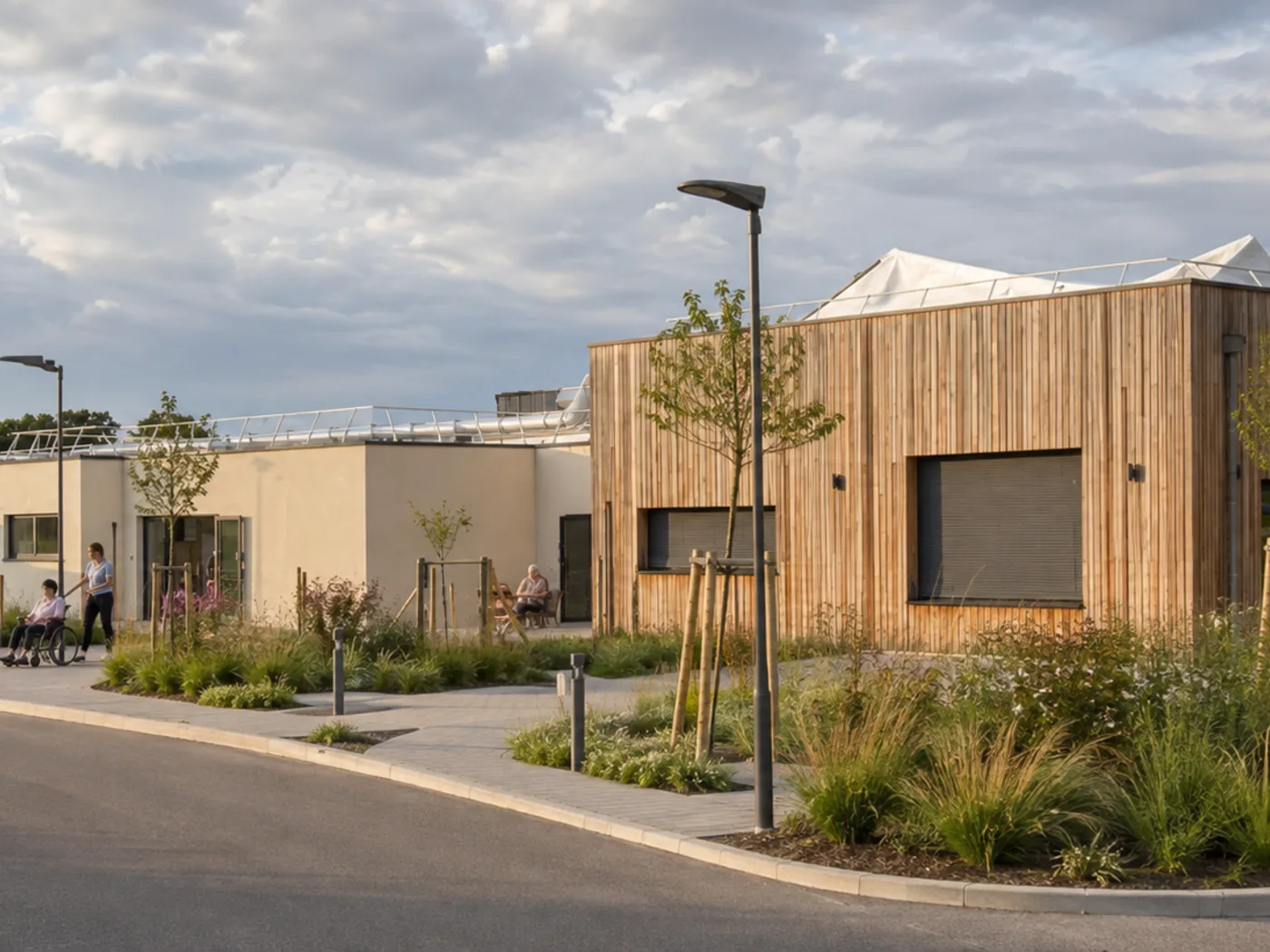 Approach to the building in the evening light, pale render and timber volumes, covered terrace.